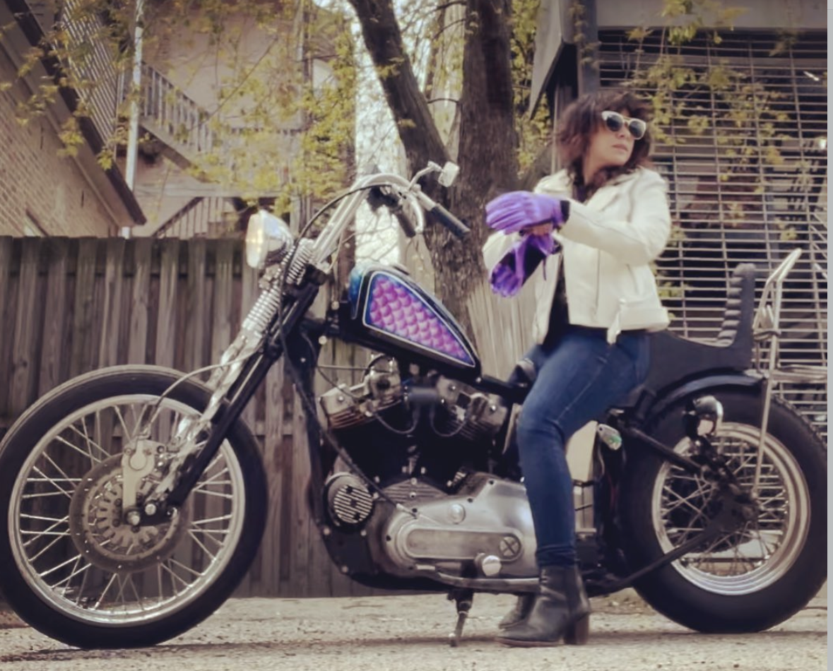 Elyse Dequiña seated on a vintage chopper motorcycle